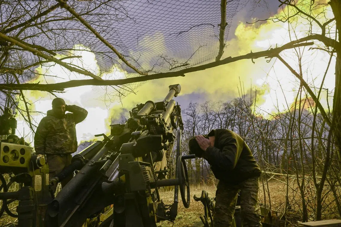 Ukrainian servicemen fire an M777 howitzer at Russian positions near Bakhmut, in eastern Ukraine, on March 17, 2023.
