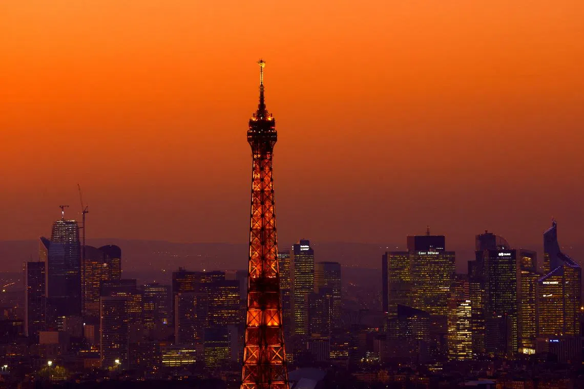 A view at sunset shows the Eiffel Tower and the financial and business district of La Defense in Puteaux near Paris, France, February 9, 2022. REUTERS/Gonzalo Fuentes/File Photo