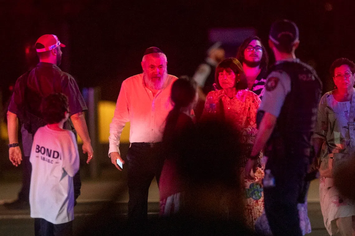 A police officer ushering pedestrians across a street near the scene of the shooting incident on Dec 14.
