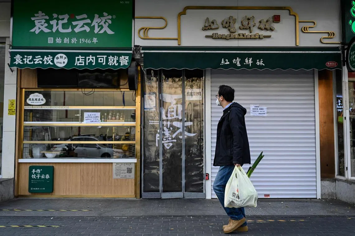 A man walks past closed shops in Beijing’s Chaoyang district on Nov 19, 2022.
