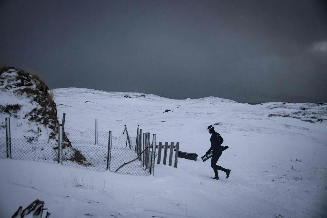 Five times freediving World Champion France's Arthur Guerin-Boeri walks towards an old traditional artic Huts, before dives in the deep to spot Orcas (Killer Whales), in the Spildra Island northern Arctic Circle, on Jan 26, 2023. 