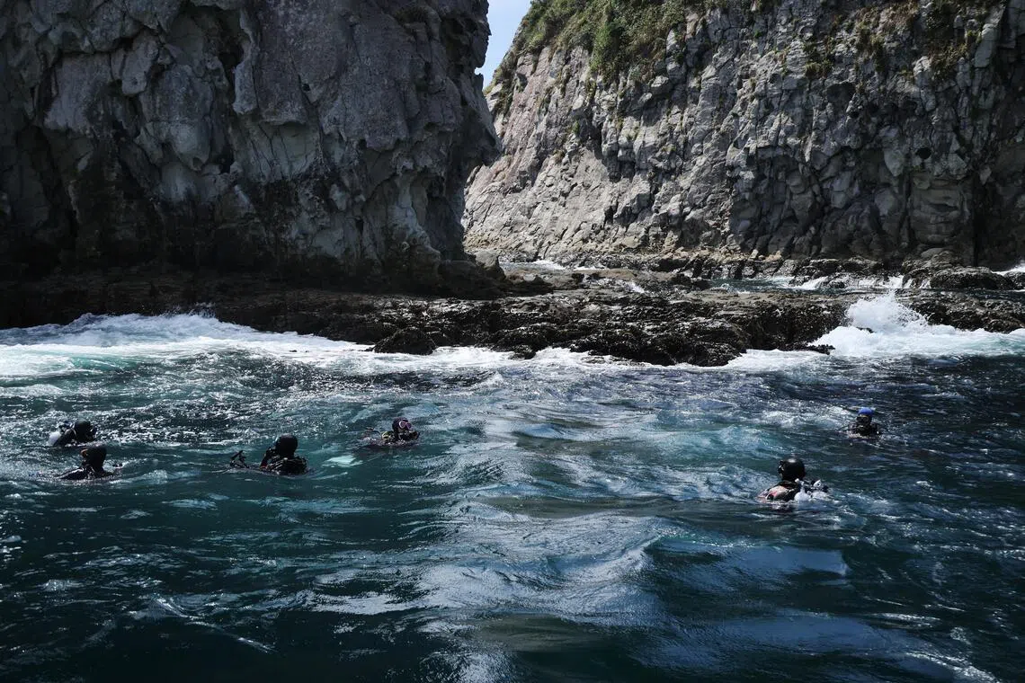 Members of the Paran Ocean Citizen Science Centre float near Mun Island, which is famous as scuba diving spot to see “coral garden” during an underwater operation to monitor coral colonies’ condition.
