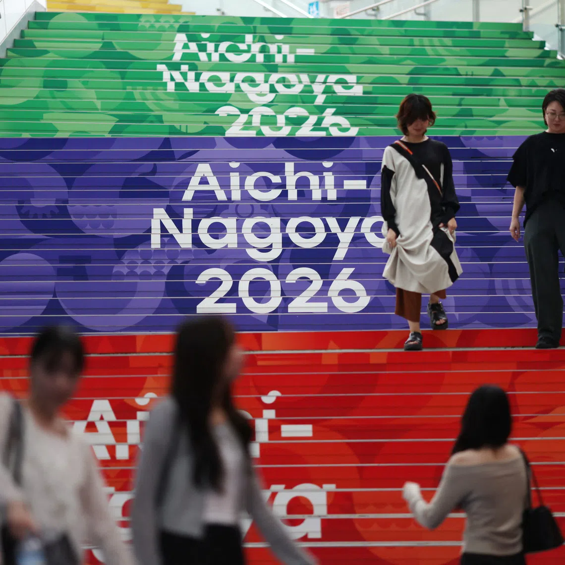 People walk past Asian Games signages in Nagoya, Japan September 14, 2026. REUTERS/Edgar Su