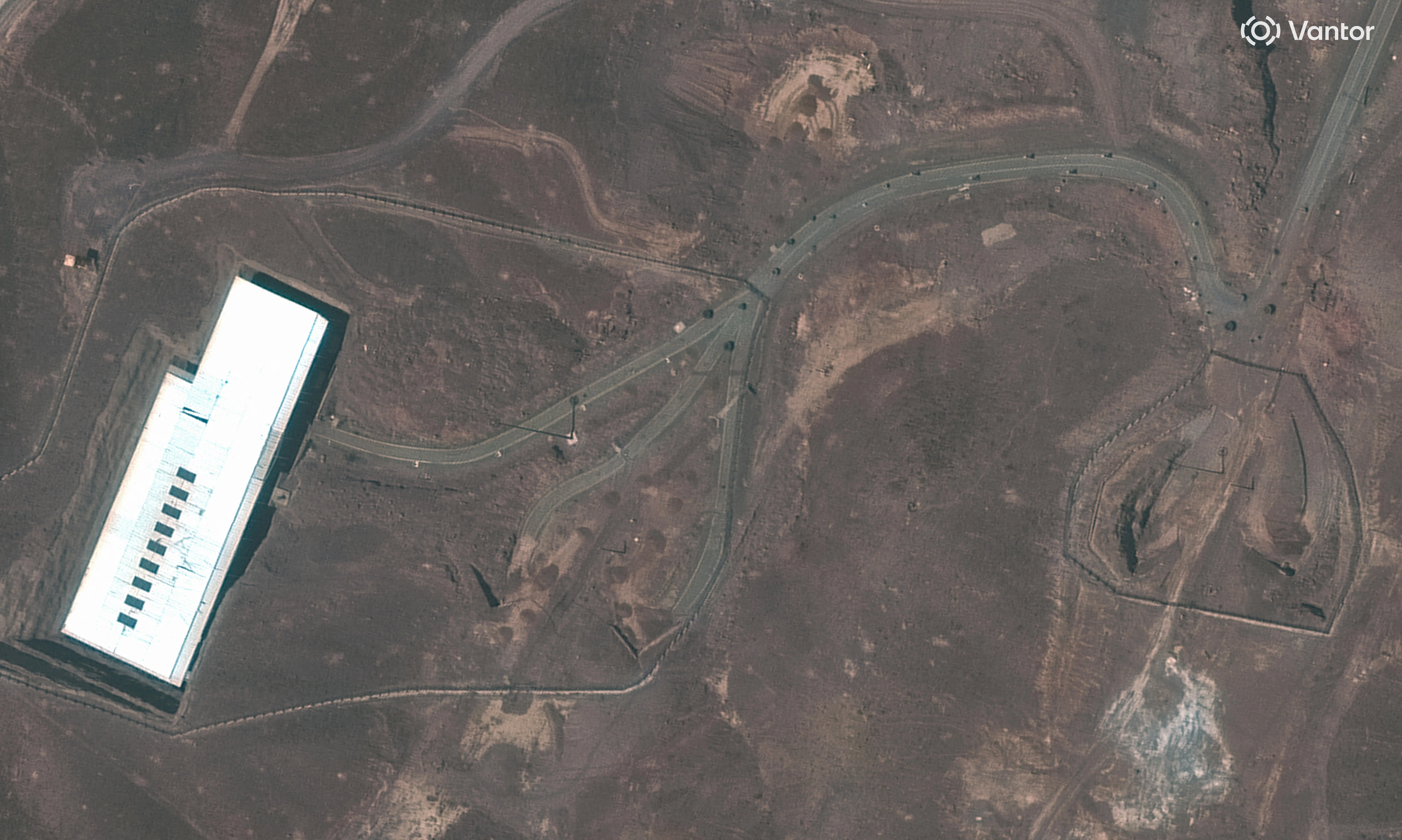 A satellite view in June showing an overview of Iran’s Fordow underground enrichment plant, with obstacles on a road, near Qom, Iran.