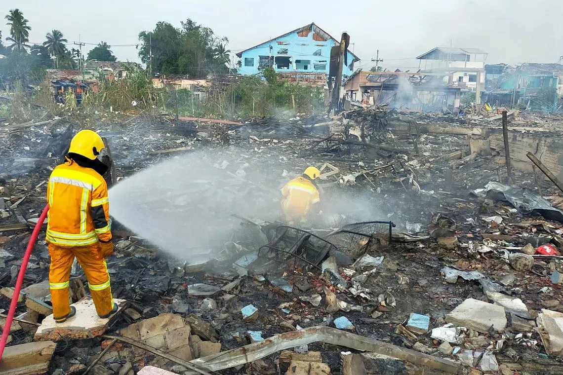 A handout photo made available by Pasemas rescue group shows Thai firefighters extinguishing a fire after an explosion at a firework warehouse in Sungai Kolok district,  southern Thailand, on July 29, 2023. 