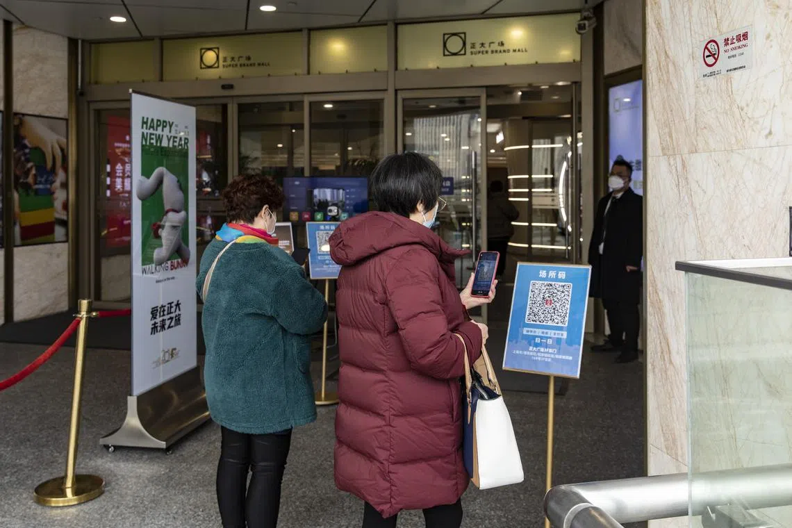Shoppers scan a health tracking code before entering a mall in Shanghai on Dec 8, 2022.