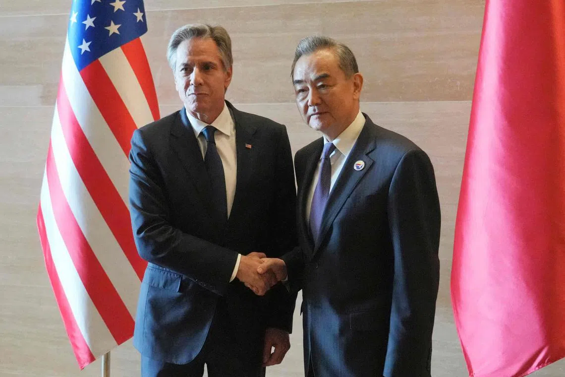 Mr Blinken (left) shakes hands with Mr Wang as they meet on the sidelines of the Asean Foreign Ministers' Meeting in Vientiane on July 27.