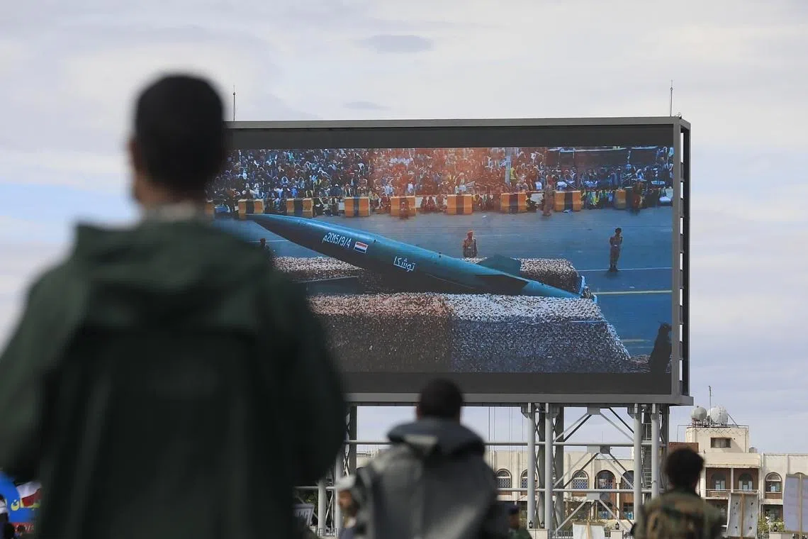 Houthi soldiers standing guard near a digital billboard featuring a missile during a rally in solidarity with Iran in Sana’a, Yemen, on March 27.