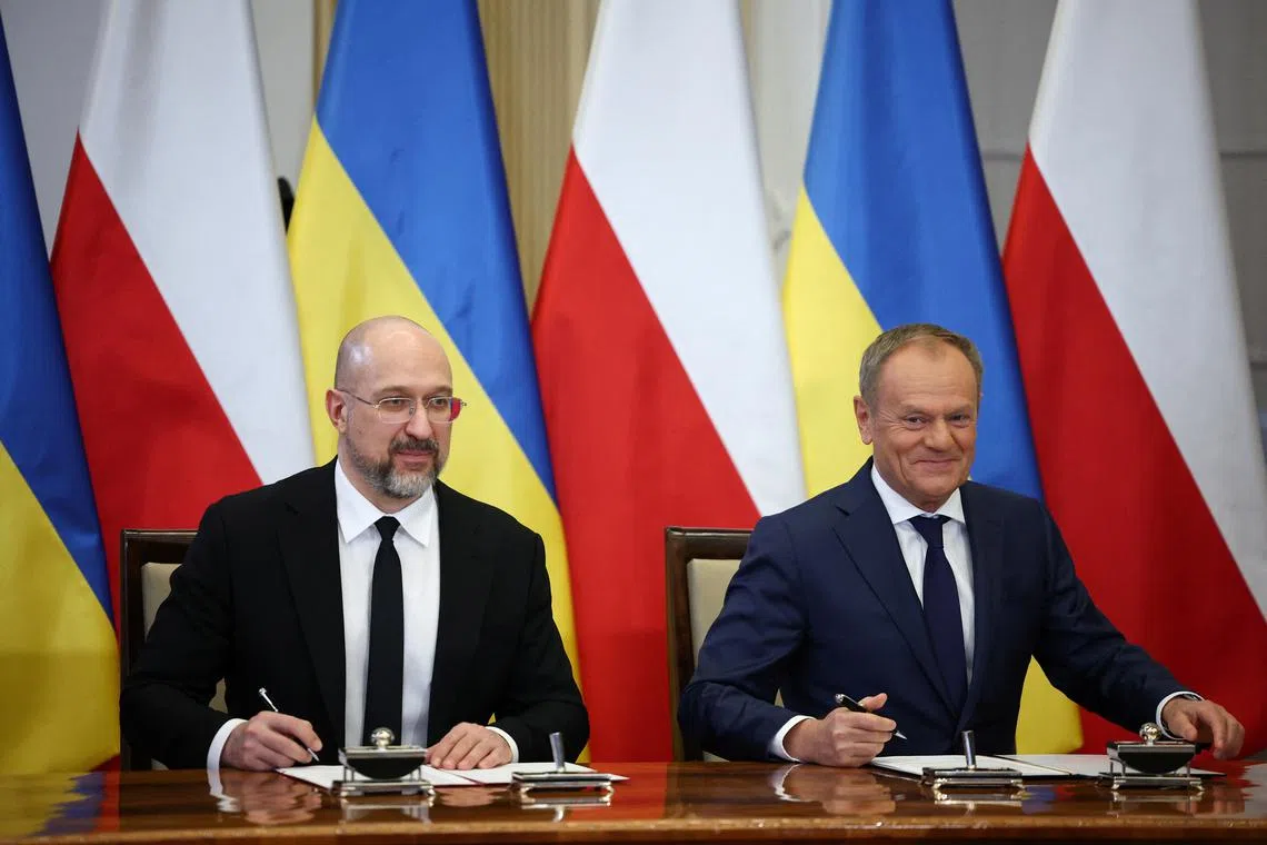 Polish Prime Minister Donald Tusk and Ukrainian Prime Minister Denys Shmyhal look on as they sign documents during a joint press conference in Warsaw, Poland, March 28, 2024. REUTERS/Kacper Pempel