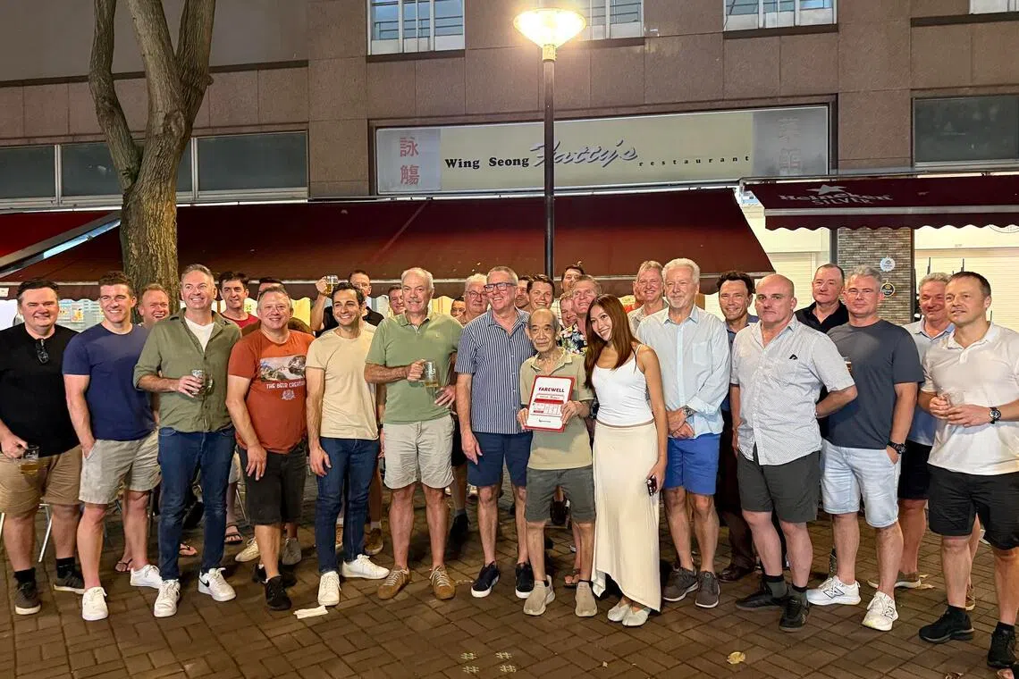 Active and retired Qantas pilots and crew present Skinny with a scrapbook of memories at the storefront of Wing Seong Fatty’s Restaurant on June 19.