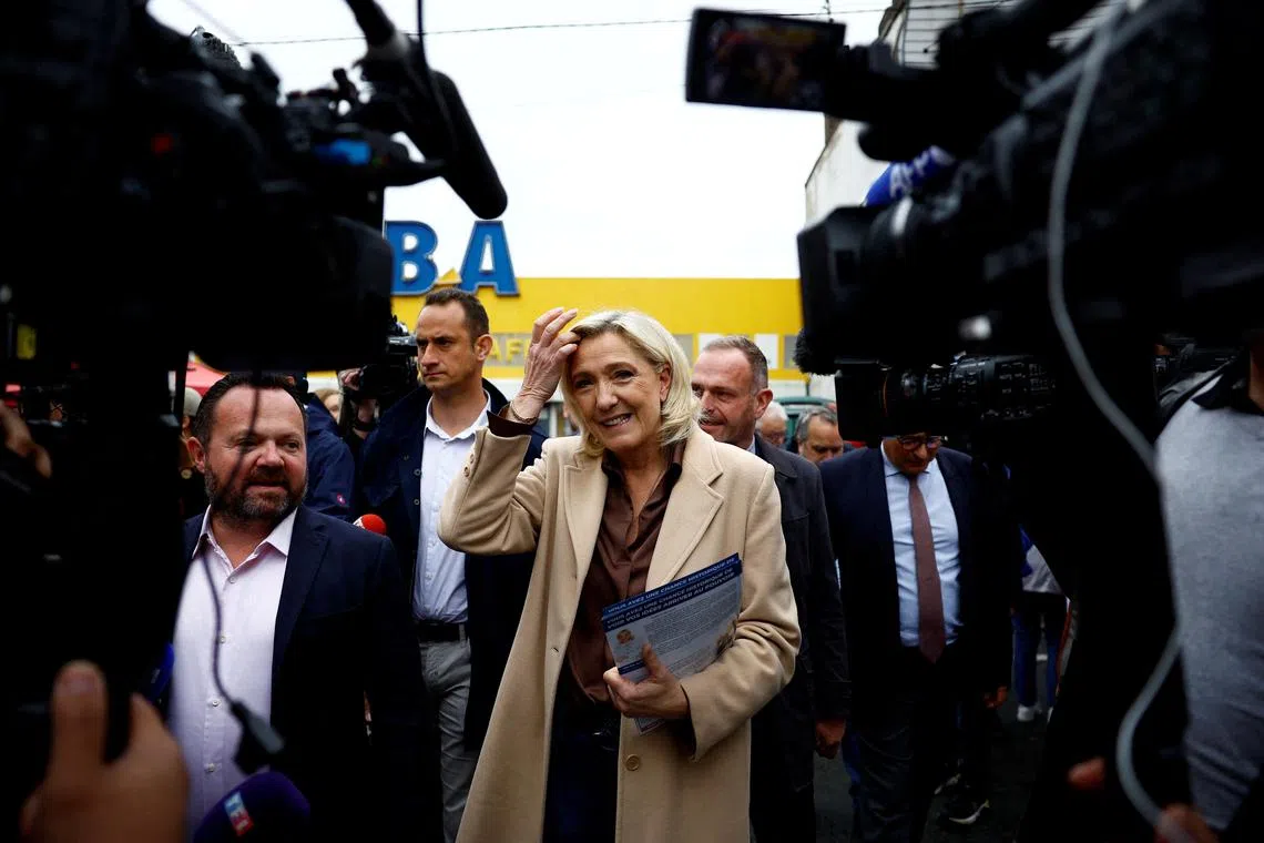 Marine Le Pen, French far-right leader and French far-right National Rally (Rassemblement National - RN) party candidate in the upcoming parliamentary elections, distributes leaflets as she campaigns with Henin-Beaumont mayor Steeve Briois and local RN politician Bruno Bilde at a market in Henin-Beaumont, northern France, June 14, 2024. REUTERS/Sarah Meyssonnier/File Photo