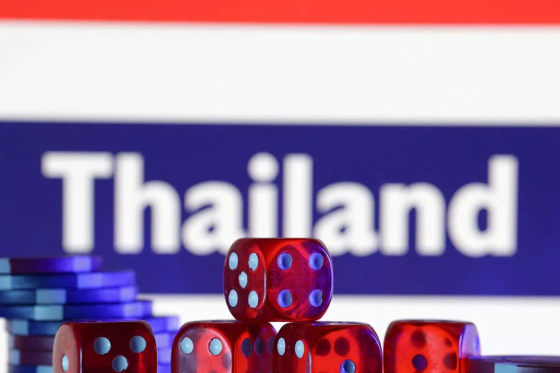 FILE PHOTO: Gambling cubes and chips are seen in front of a displayed Thailand flag and the word \"Thailand\" on it in this illustration taken February 11, 2025. REUTERS/Dado Ruvic/Illustration/File Photo