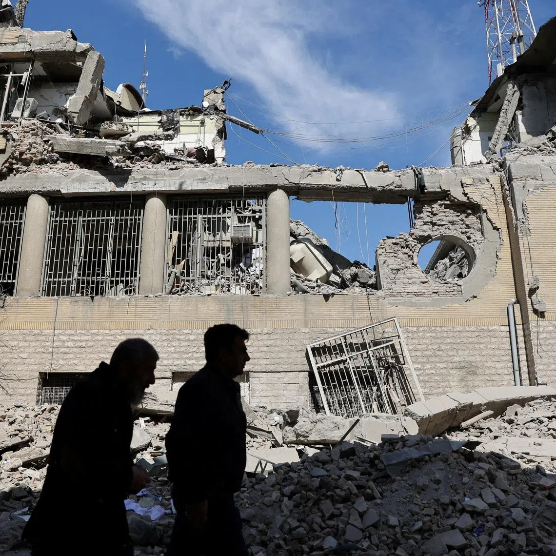 People walk past damaged buildings following a strike on a police station, amid the U.S.-Israeli conflict with Iran, in Tehran, Iran, March 4, 2026. Majid Asgaripour/WANA (West Asia News Agency) via REUTERS