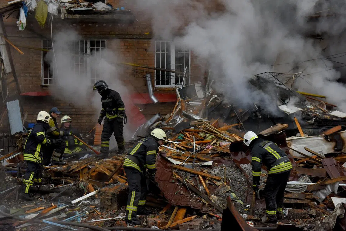 Ukrainian firefighters work at the site of an apartment block destroyed by Russian shelling in Vyshhorod, near Kyiv.