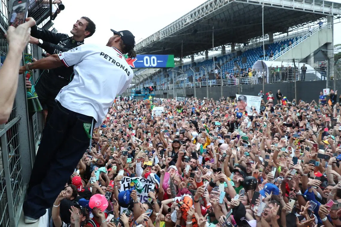 Winner British Formula One driver George Russell (L) of Mercedes-AMG Petronas and second placed British Formula One driver Lewis Hamilton (2L) of Mercedes-AMG Petronas celebrates with supporters after the Formula One Brazilian Grand Prix, in Sao Paulo, Brazil, 13 November 2022.  