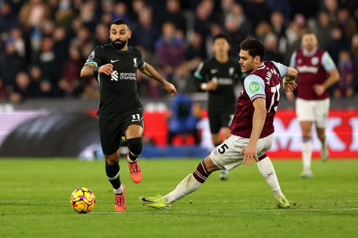 Liverpool's Egyptian striker #11 Mohamed Salah runs with the ball from West Ham United's Greek defender #15 Konstantinos Mavropanos during the English Premier League football match between West Ham United and Liverpool at the London Stadium, in London on December 29, 2024. (Photo by Adrian Dennis / AFP) / RESTRICTED TO EDITORIAL USE. No use with unauthorized audio, video, data, fixture lists, club/league logos or 'live' services. Online in-match use limited to 120 images. An additional 40 images may be used in extra time. No video emulation. Social media in-match use limited to 120 images. An additional 40 images may be used in extra time. No use in betting publications, games or single club/league/player publications. /