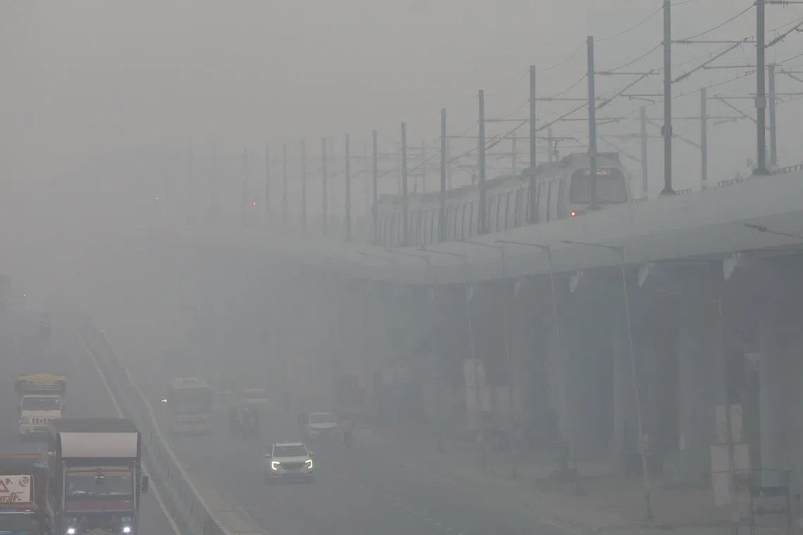 A train moves through smog on the outskirts of Delhi on Oct 23. 