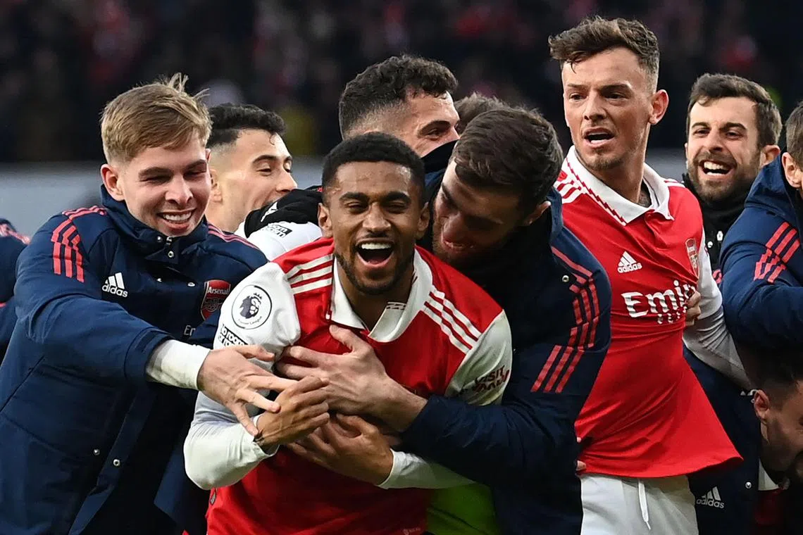 Arsenal's Reiss Nelson (centre) celebrates after scoring his team's third goal during stoppage time.
