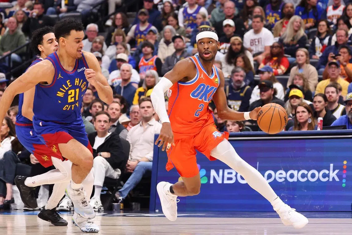 Shai Gilgeous-Alexander of the Oklahoma City Thunder drives to the basket against Spencer Jones of the Denver Nuggets during the fourth quarter at Ball Arena.