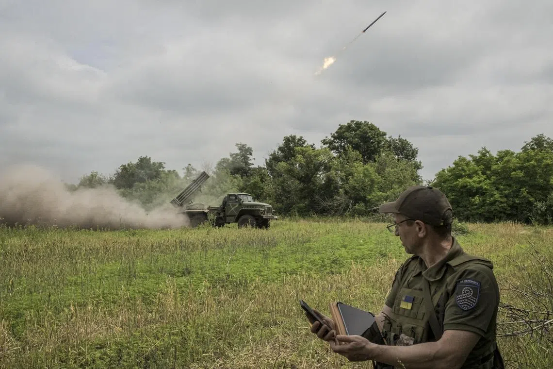  A Ukrainian soldier checks coordinates as his team fires a rocket in the Donetsk region.