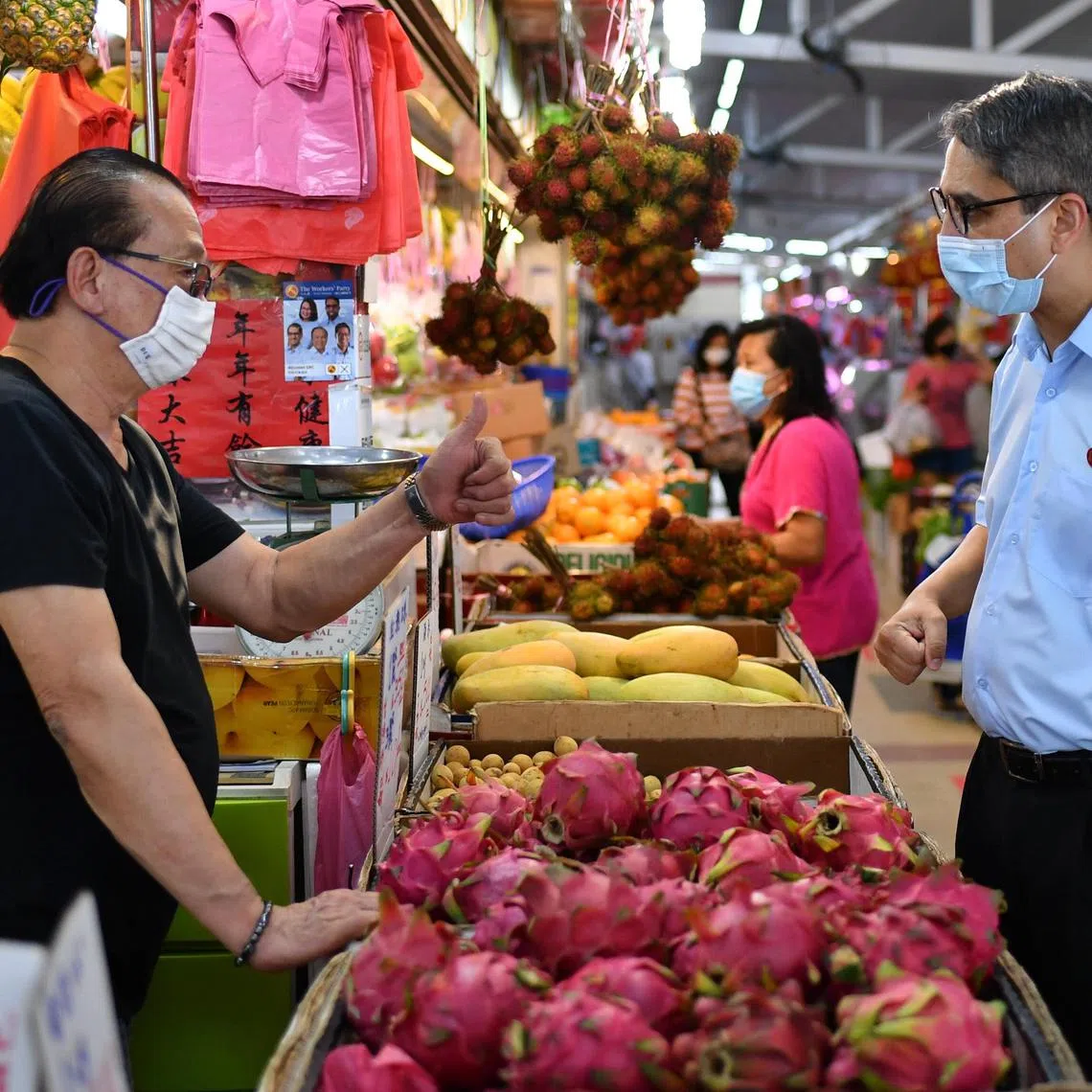 Mr Leon Perera (right), then a candidate for Aljunied GRC, during a walkabout at Kovan Market on July 2, 2020. 