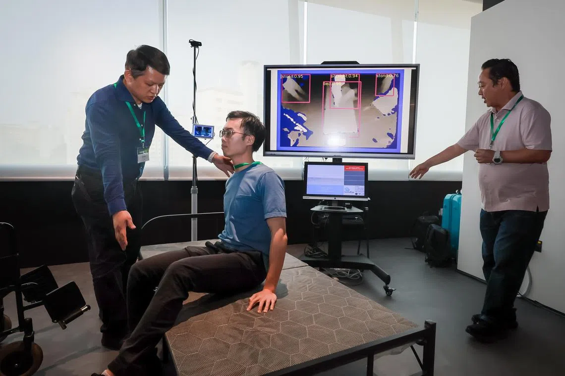 A demonstration of a mobile fall detection system to monitor patients in both bed and wheelchair settings at a media preview at Synapxe’s Terrarium innovation lab.