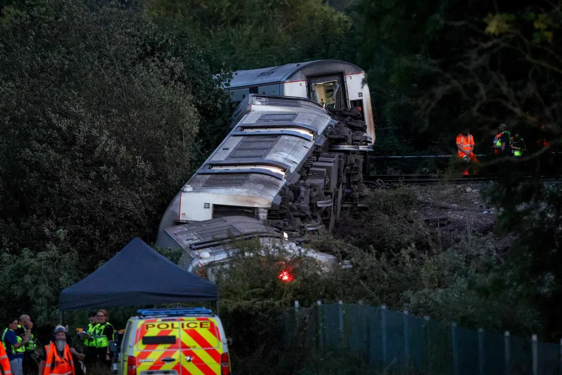 Emergency personnel working at the scene next to an overturned train after a passenger Southern service derailed near Lewes, south-east Britain, on Aug 13.