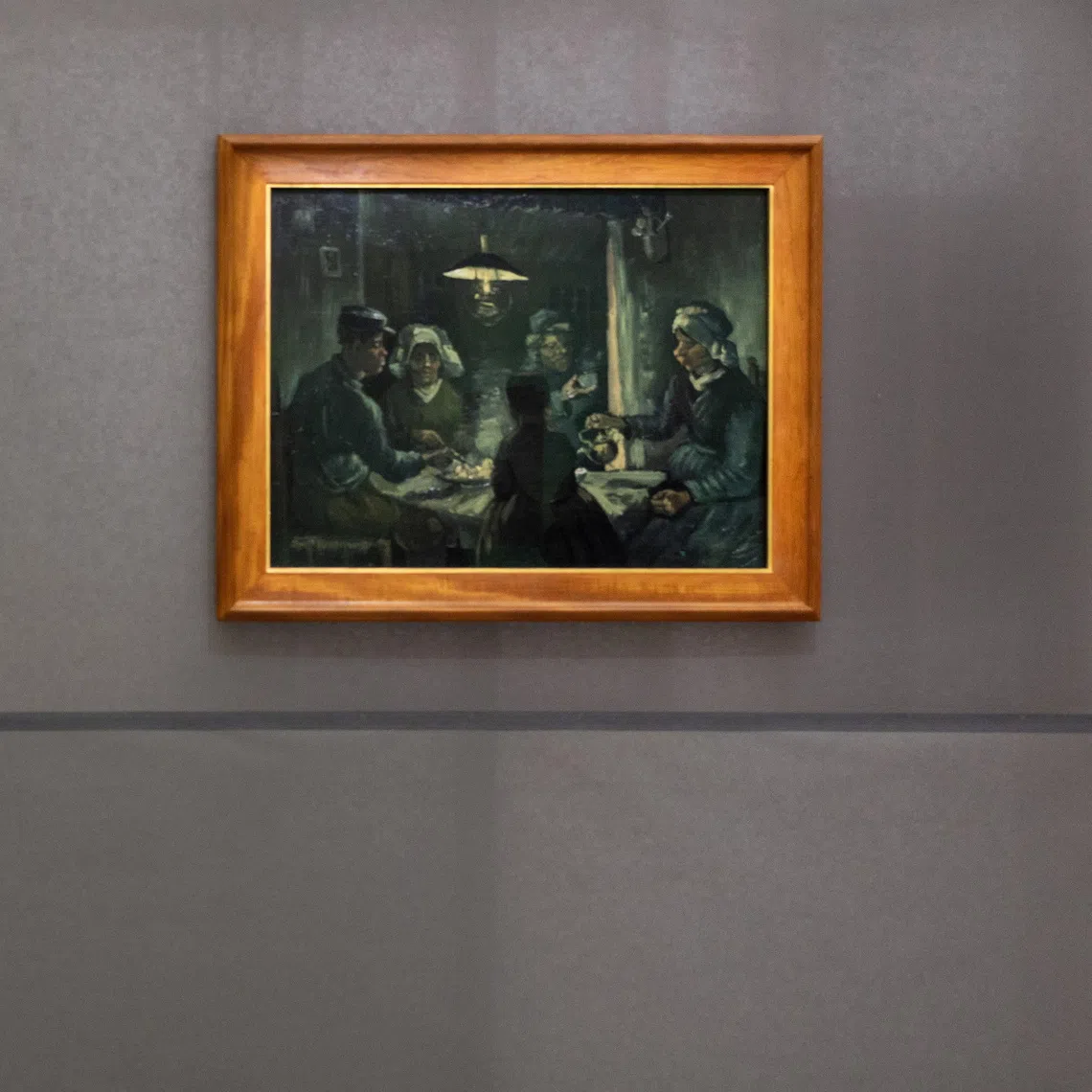 A visitor viewing the paintings (from left) Madame Ginoux, Cafe Terrace at Night, Portrait of Joseph-Michel Ginoux, and a preliminary study of The Potato Eaters by Vincent Van Gogh at the Kroeller-Mueller Museum in Otterlo, Netherlands.
