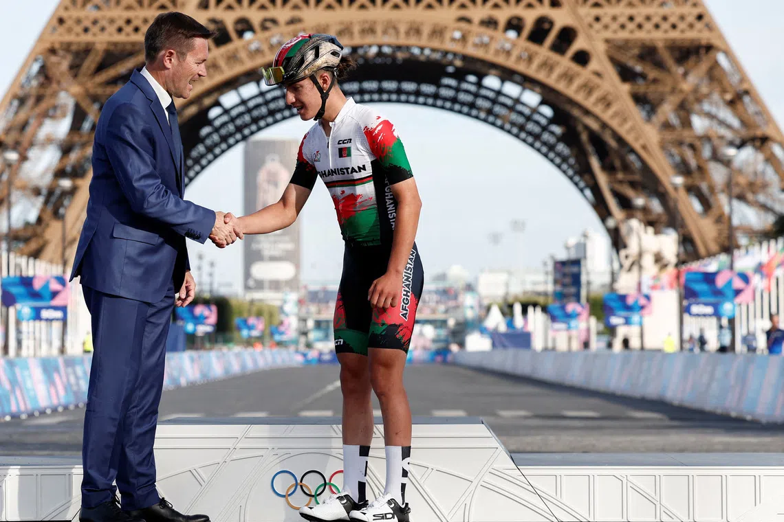 Paris 2024 Olympics - Road Cycling - Women's Road Race Victory Ceremony - Trocadero, Paris, France - August 04, 2024. UCI President David Lappartient shakes hands with Fariba Hashimi of Afghanistan. REUTERS/Benoit Tessier