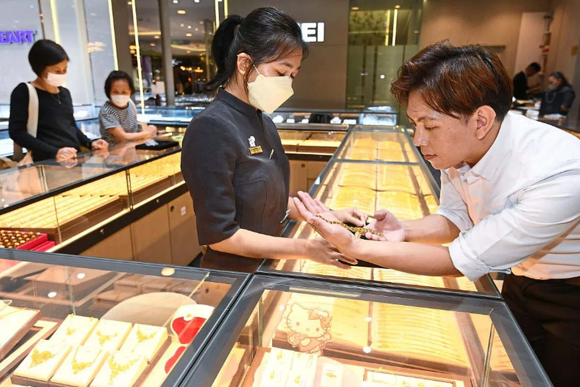 A customer checking out a gold necklace at a goldsmith shop in Kuala Lumpur. 