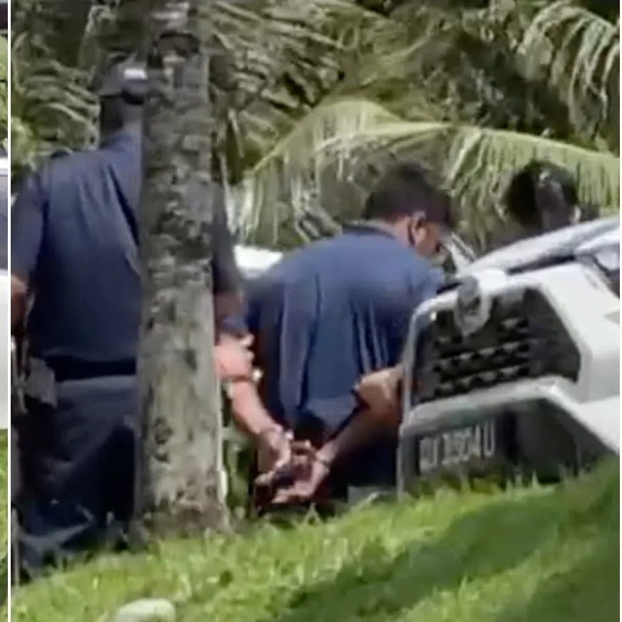 At about 1.45pm, a handcuffed man wearing a blue top was led to a white car by police officers. 