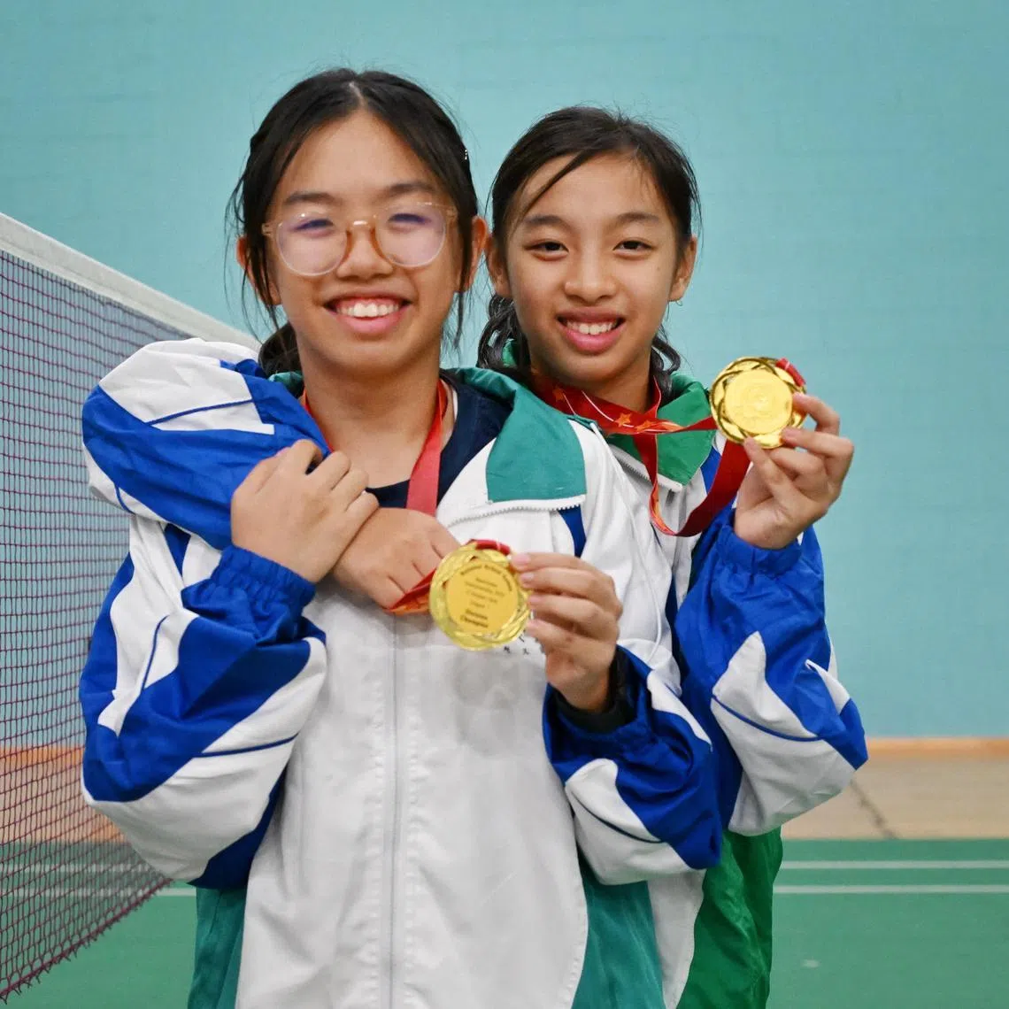 Sisters Emma (right) and Ellie Ang of CHIJ St Nicholas Girls' School celebrating their win at the National School Games C Division girls final at the OCBC Arena, on Aug 27, 2025.