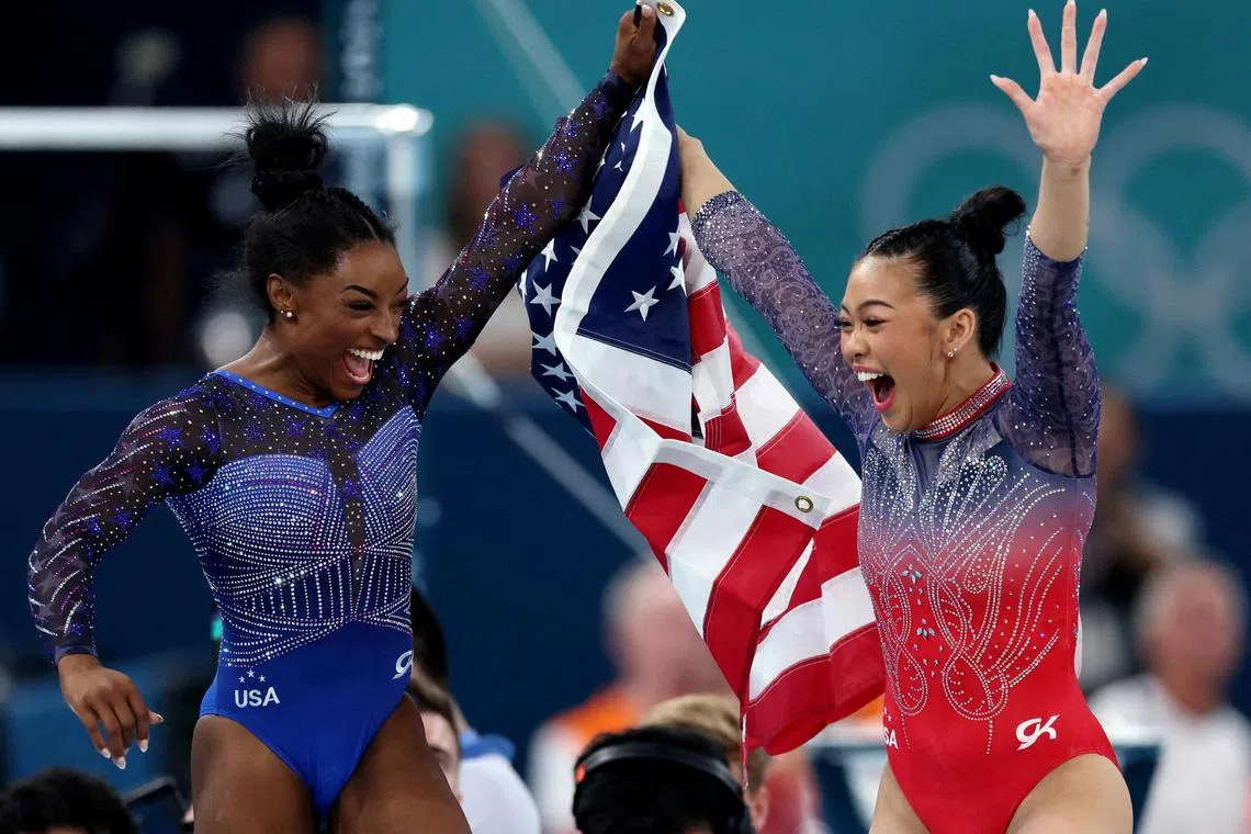Simone Biles (left) and Sunisa Lee, both of the US, celebrate after winning gold and bronze respectively in the women's all-around gymnastics.