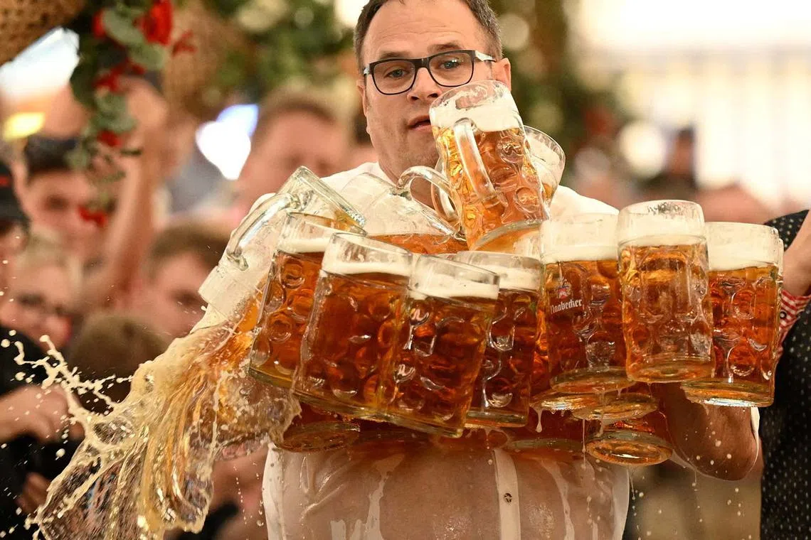 Oliver Strumpfel attempting to break the world record for beer-mug carrying with 31 mugs, but he drops some mugs along the way, at the Gillamoos festival in Abensberg, Germany, Sept 7, 2025. 