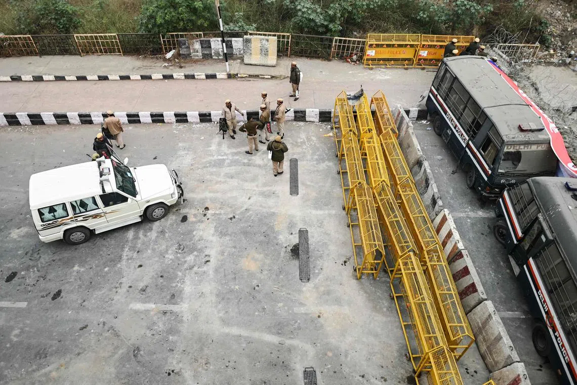 Security personnel stand guard at a road block during a nationwide strike called by farmers, along the Ghazipur New Delhi-Uttar Pradesh state border.
