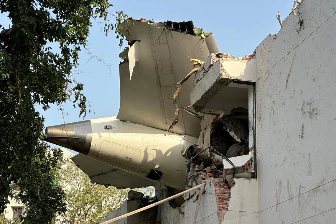 FILE PHOTO: A tail of an Air India Boeing 787 Dreamliner plane that crashed is seen stuck on a building after the incident in Ahmedabad, India, June 12, 2025. REUTERS/Amit Dave/File Photo