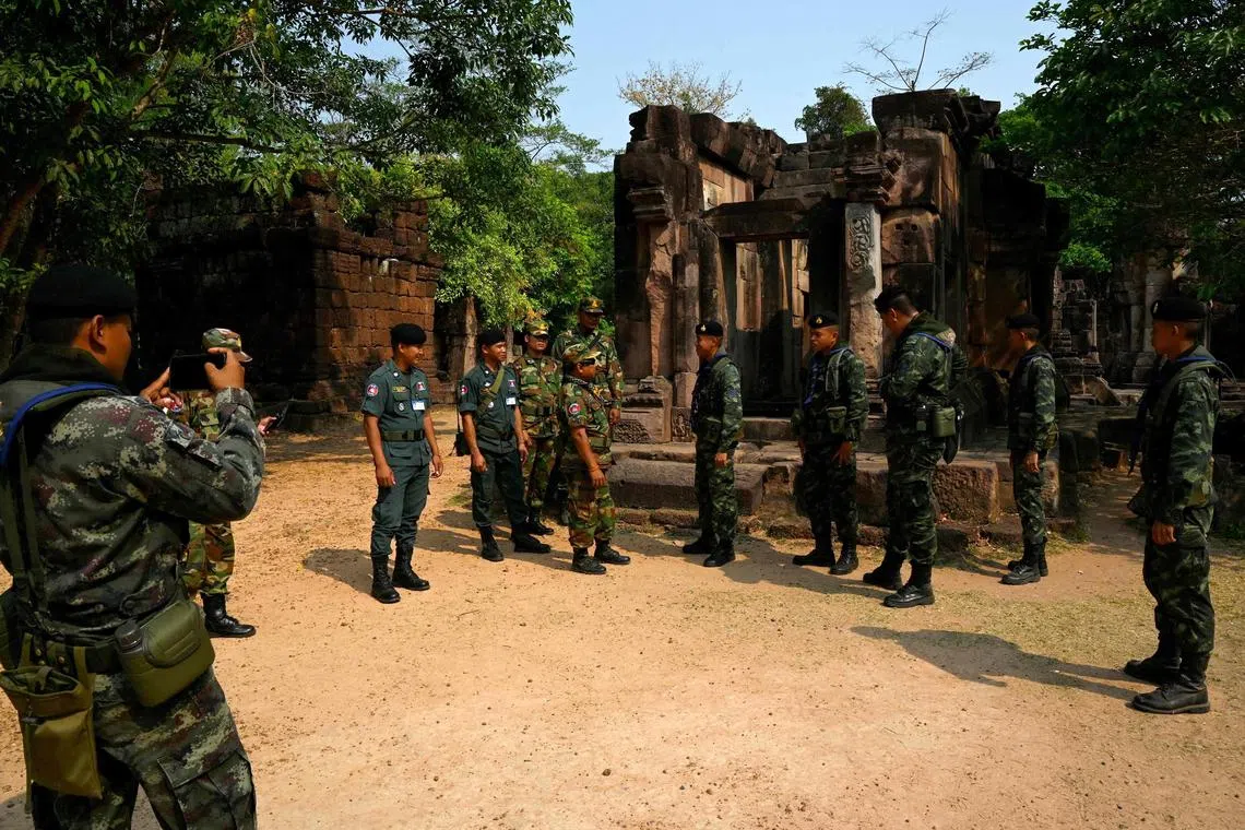 Thai and Cambodian soldiers talk along a disputed part of the Thai-Cambodian border.