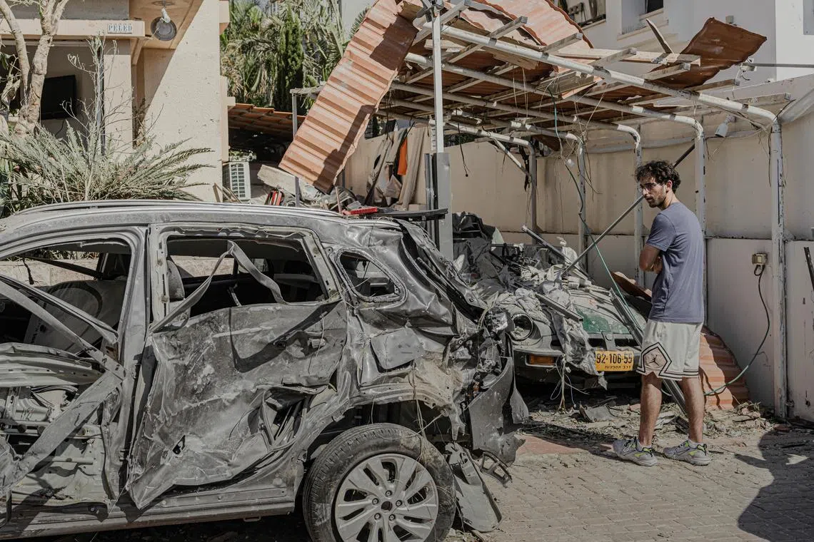 A resident surveys damage outside of his home, which was hit by an Iranian missile in Rishon LeZion, Israel, just south of Tel Aviv, on June 14. 