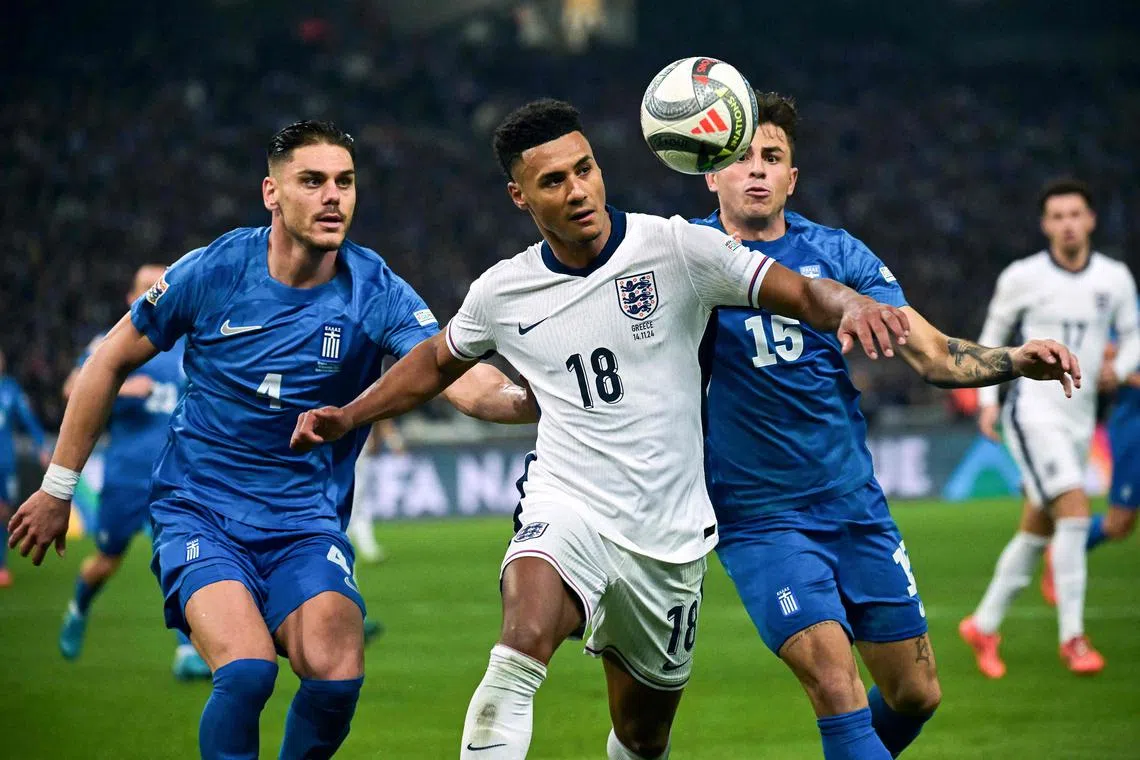 England forward Ollie Watkins (centre) fighting for the ball with Greece's defender Lazaros Rota (right) during the Nov 14 match.