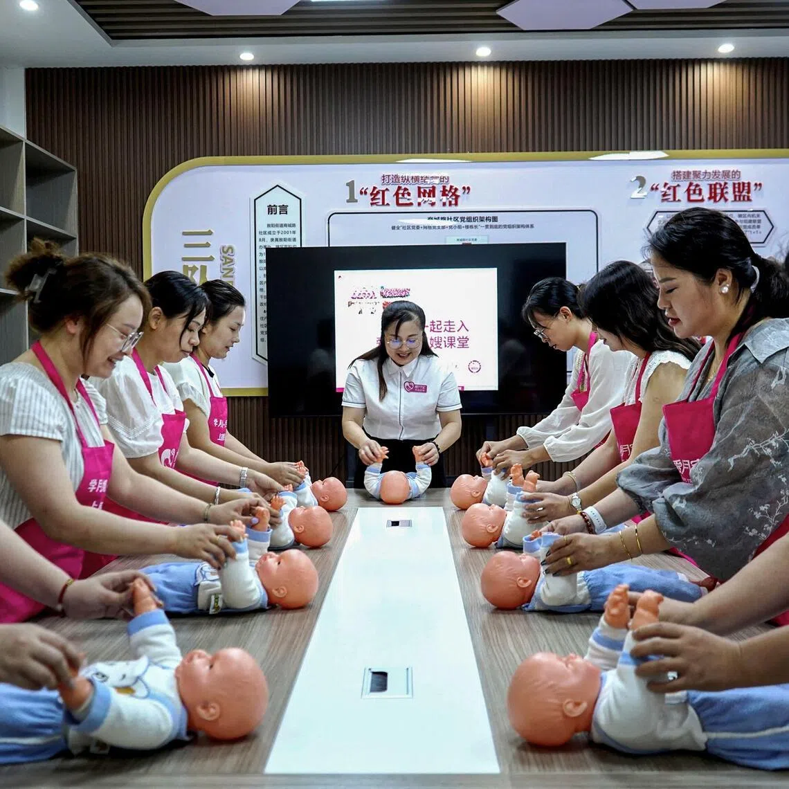 (FILES) Women learn knowledge of taking care of mothers and newborn babies in a neighborhood committee in Yichun in central China's Jiangxi province on August 21, 2024. China's birth rate fell last year to its lowest level on record, official data showed on January 19, 2026, as its population shrank for a fourth year running despite authorities' efforts to curb the decline. (Photo by AFP) / China OUT