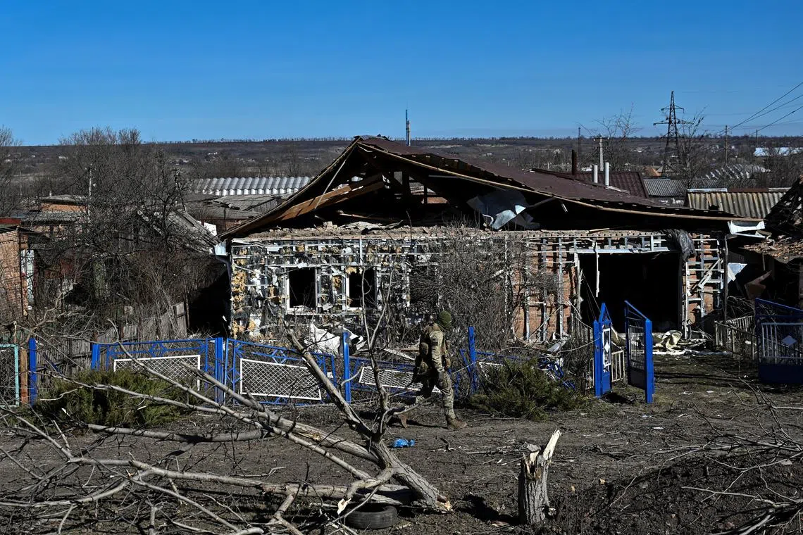 A police officer walks past a damaged house in the frontline town of Orikhiv, amid Russia's attack on Ukraine, in Zaporizhzhia region, Ukraine February 28, 2024. REUTERS/Stringer