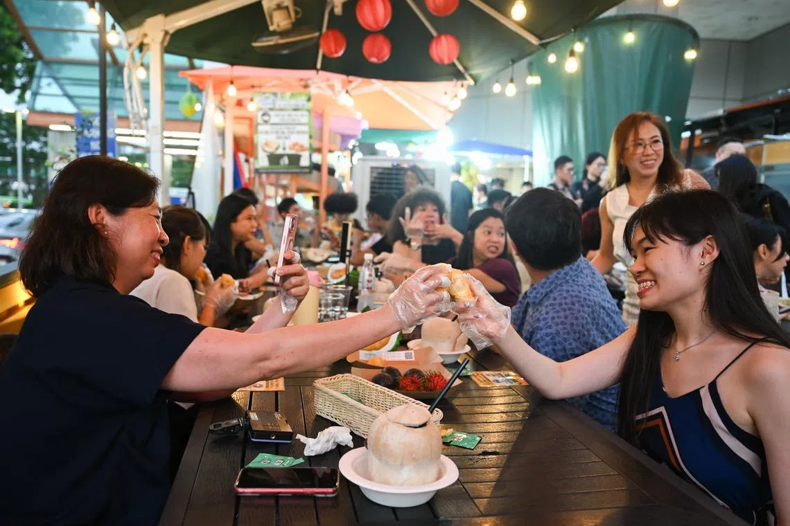 People trying durians at the launch of AGONG Durian at an event at Thomson Plaza on July 9.