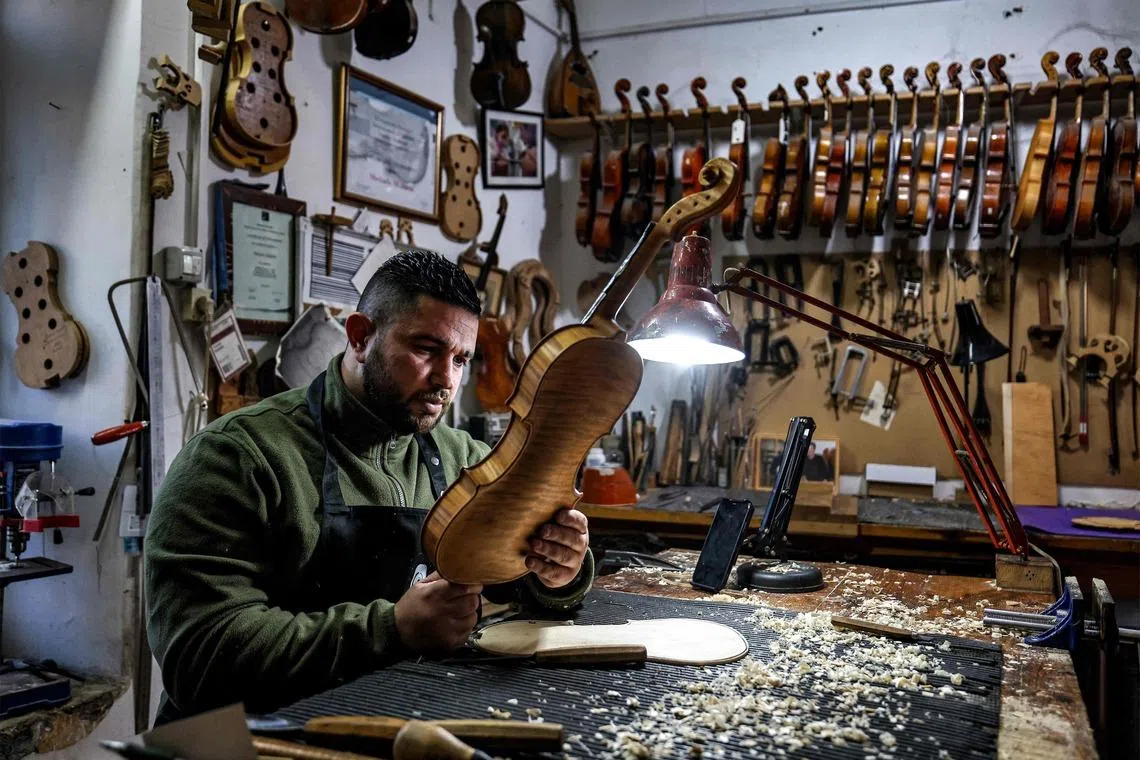 Palestinian musical instrument maker Shehada Shalalda assembling a violin under construction at his workshop in Ramallah in the occupied West Bank on Feb 4, 2026. 