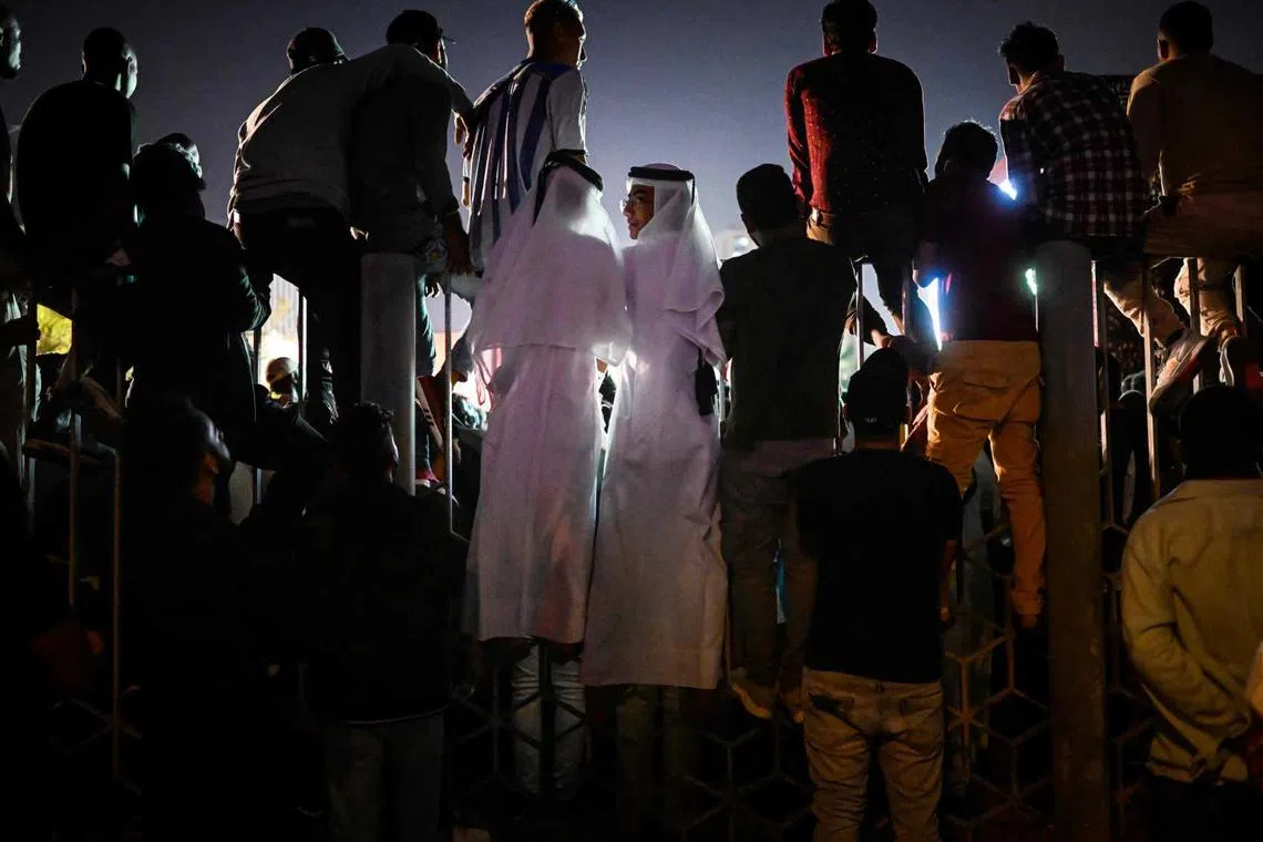 People watch a live broadcast of the 2022 World Cup opening match between Qatar and Ecuador at the Hayya Fan Zone at the Doha's Corniche promenade, in Doha, on Nov 20, 2022, during the Qatar 2022 World Cup football tournament.