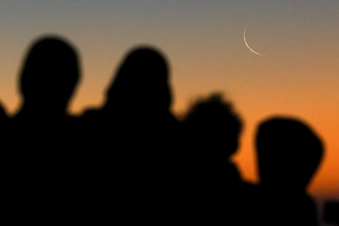 Muslims looking at the sighting of the crescent moon that marks the start of the holy month of Ramadan on Sea Point promenade in Cape Town, South Africa, on Mar 11, 2024. 