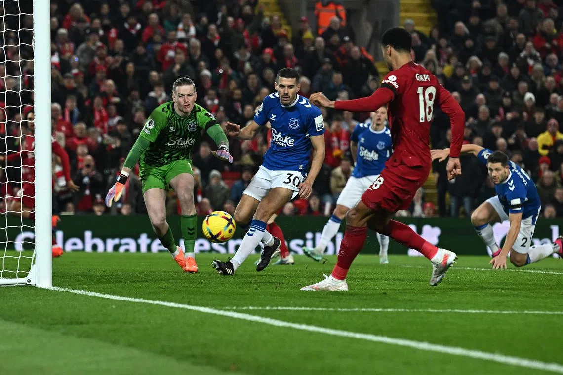 Liverpool striker Cody Gakpo scoring their second goal past Everton's Jordan Pickford en route to a 2-0 win at Anfield.