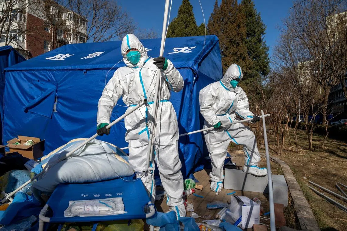 Workers dismantle a temporary shelter outside a neighborhood placed under lockdown in Beijing on Dec 1, 2022.