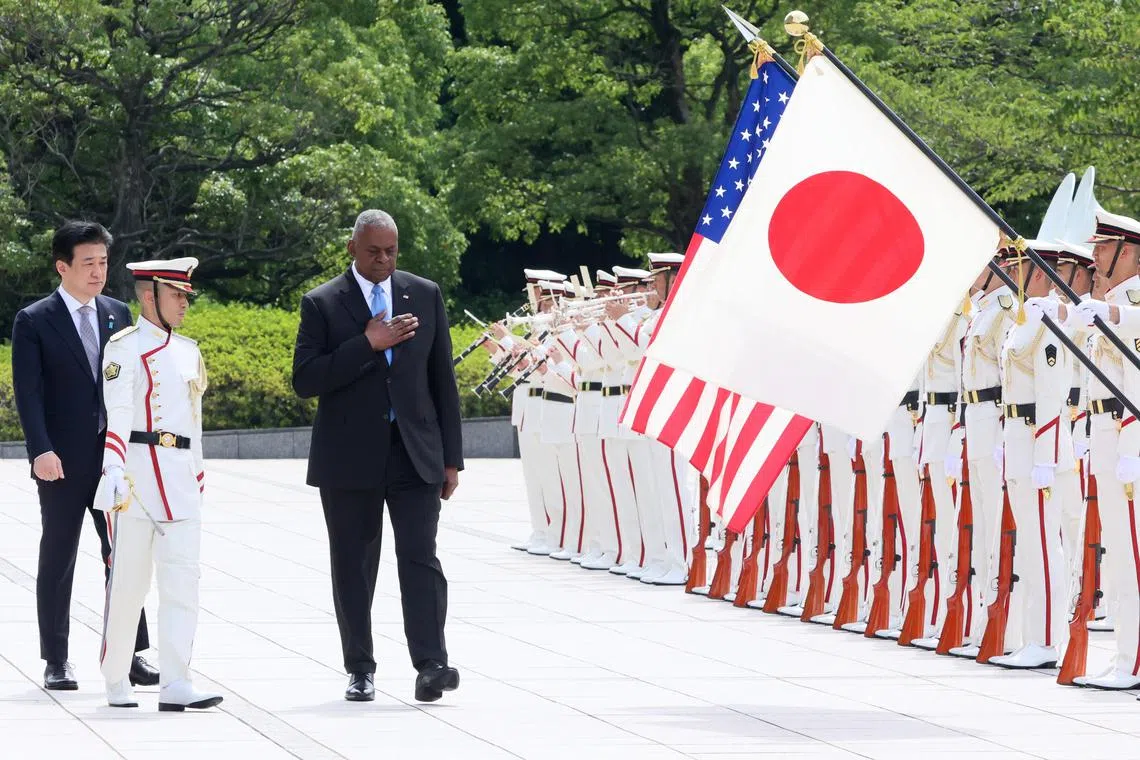US Secretary of Defence Lloyd Austin (C), accompanied by Japanese Defence Minister Minoru Kihara (L), reviews the guard-of-honour prior to a Japan-USA-South Korea trilateral defence ministers meeting in Tokyo on 28 July 2024.
