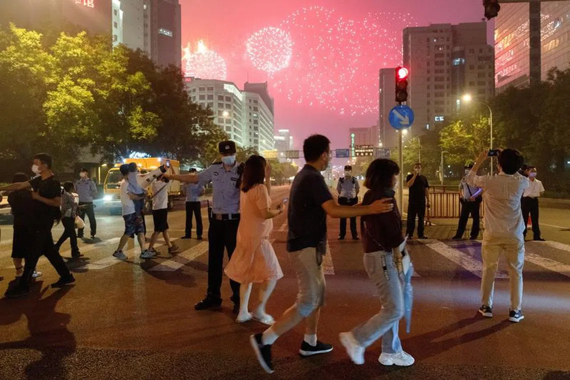 FILE PHOTO: People watch a rehearsal of a fireworks display near the National Stadium ahead of the 100th founding anniversary of the Communist Party of China in Beijing, China June 25, 2021. REUTERS/Thomas Peter/File Photo