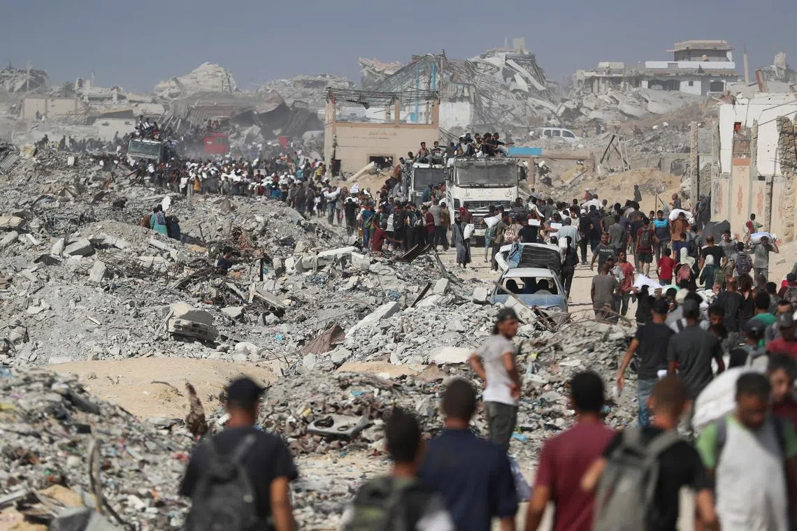 FILE PHOTO: Palestinians carry aid supplies that entered Gaza through Israel, in Beit Lahia, northern Gaza Strip, August 2, 2025. REUTERS/Mahmoud Issa/File Photo